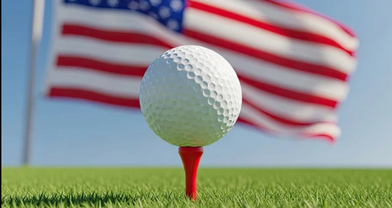 Golf ball on a tee with an American flag behind.